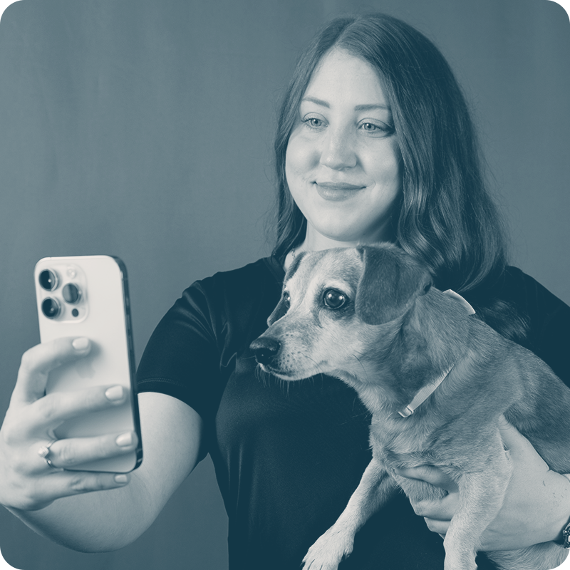 Girl holding dog and taking a selfie